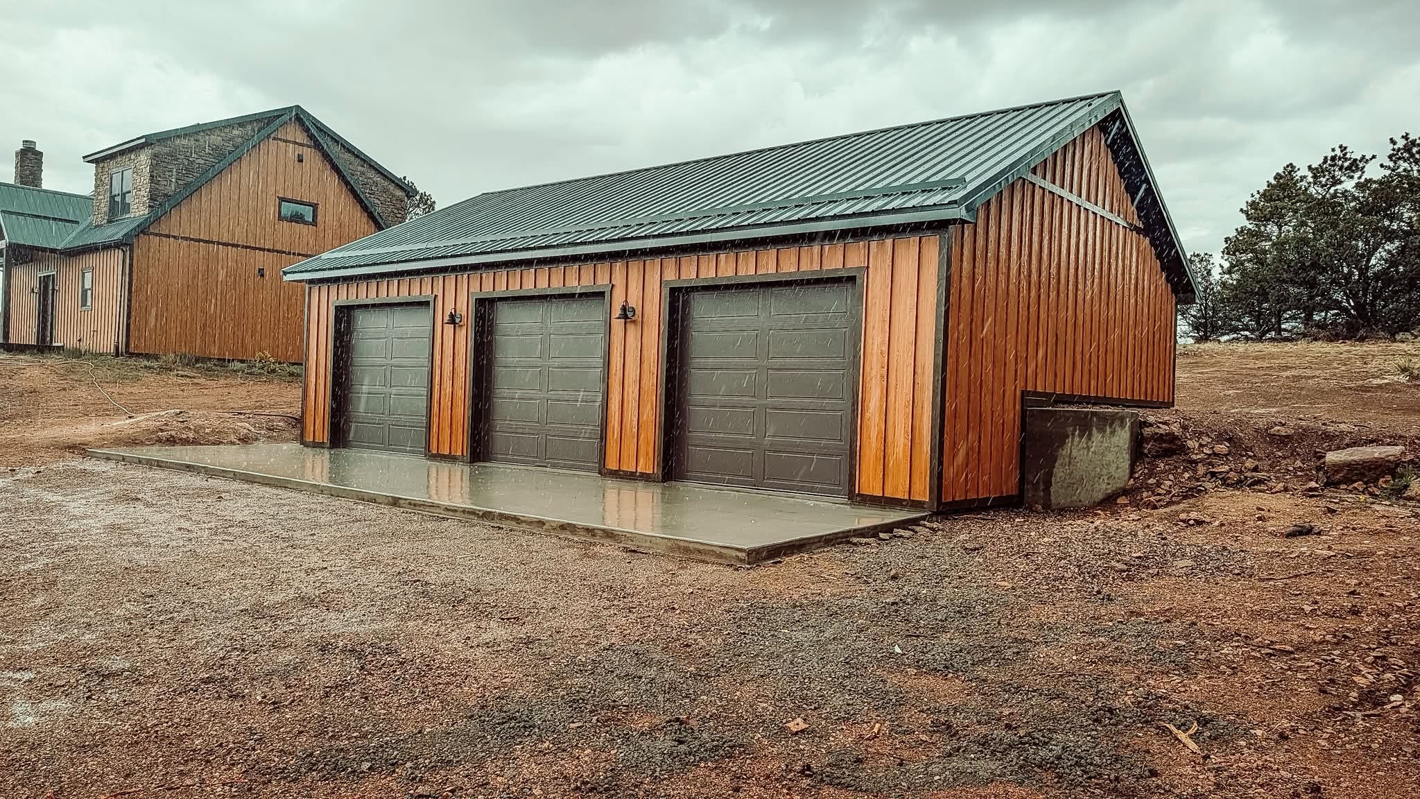 Completed Simpson garage addition with wood siding and green metal roof